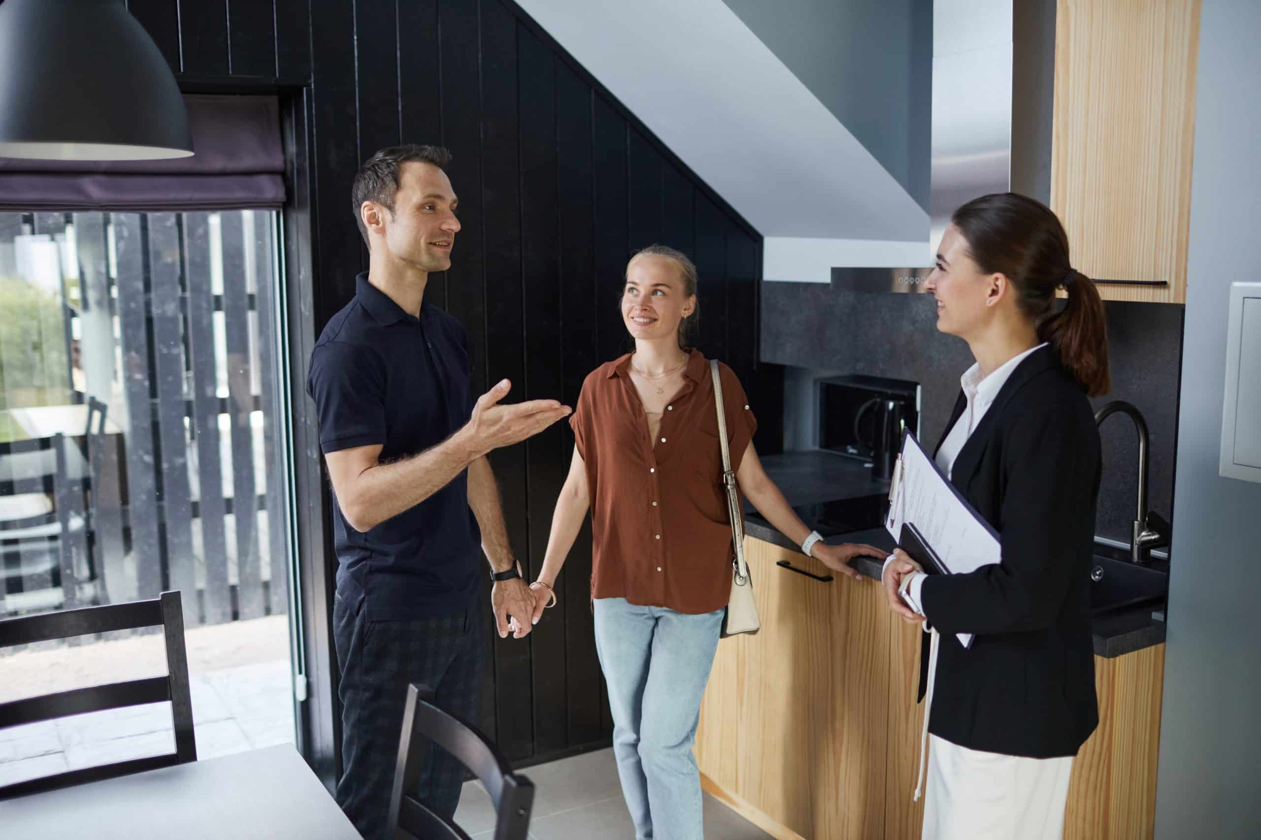 a man and woman standing in a room with a fireplace and a woman holding hands